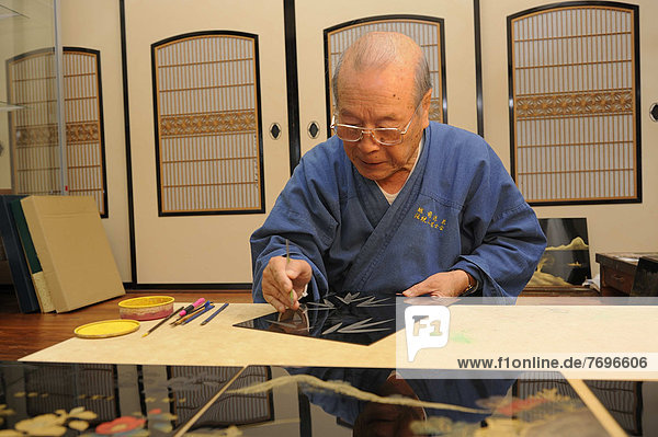 Japanese artisan in his workshop  scraping a bamboo motif into the top lacquer coat  Sabae  Fukui  Japan  East Asia  Asia