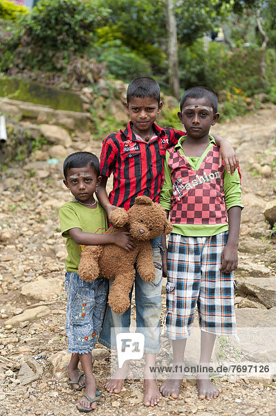Three Tamil children with a teddy bear