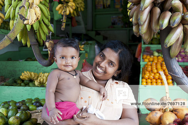 Verkäuferin mit ihrem Baby  Obst- und Gemüsestand