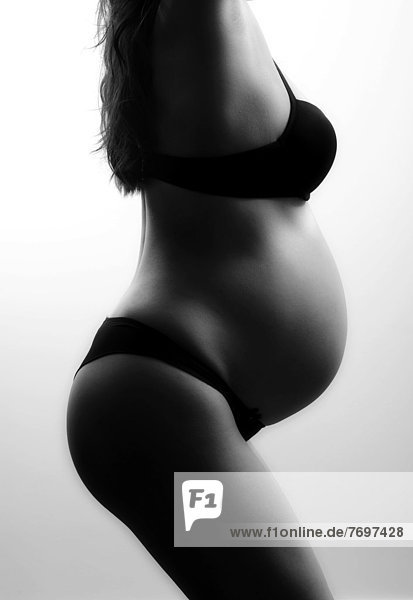 Schwangere Frau mit Schwangerschaftsbauch in Unterwäsche