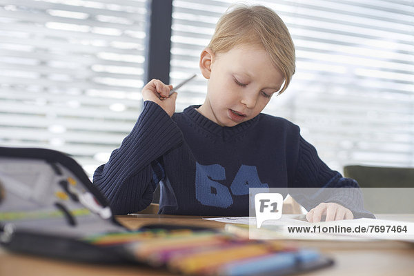 Schuljunge  7 Jahre  macht Hausaufgaben