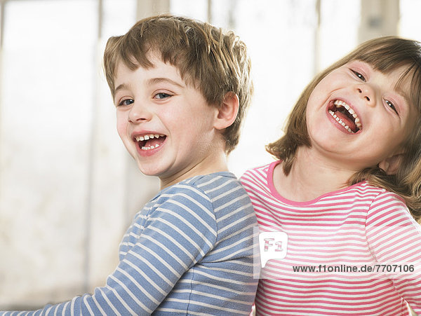 Kinder lächeln gemeinsam im Haus