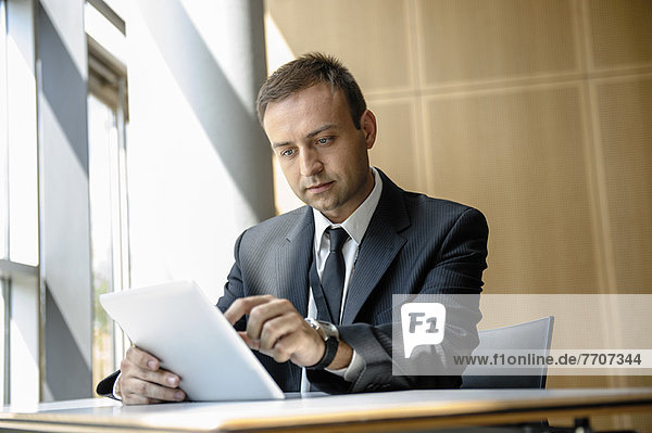 Geschäftsmann mit Tablet-Computer am Schreibtisch