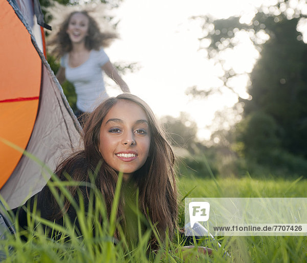 Teenage girl laying in tent at campsite