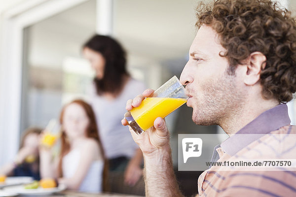Mann trinkt ein Glas Orangensaft