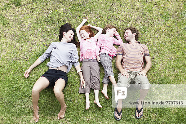 Familie zusammen im Gras liegend