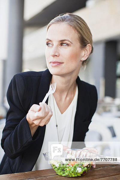 Businesswoman eating salad outdoors