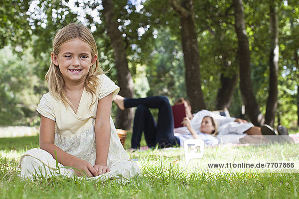 Mädchen im Park im Gras sitzend