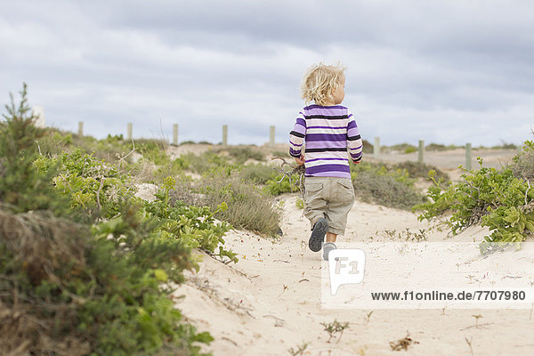 Toddler girl walking on beach