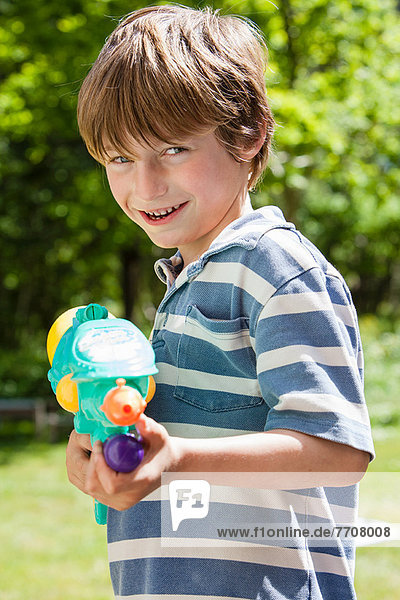 Boy holding water gun outdoors