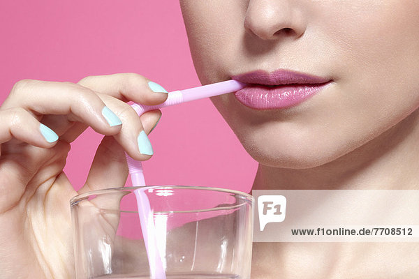Close up of woman drinking with straw