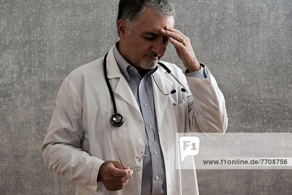 Männlicher Arzt sieht gestresst aus