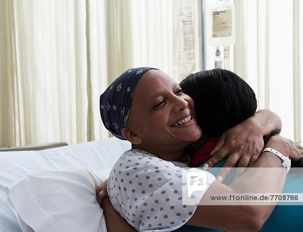Tochter umarmt Mutter im Krankenhaus