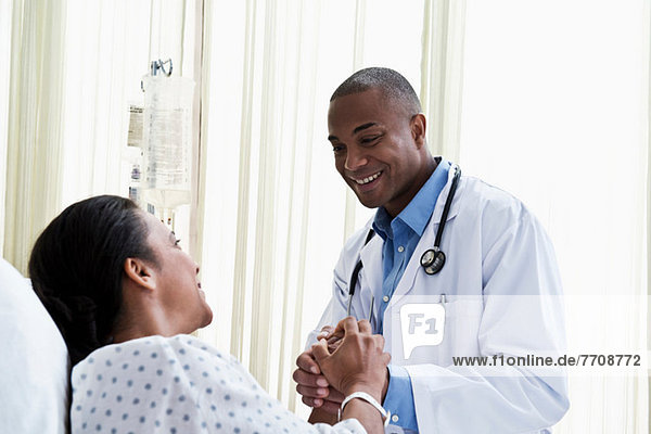 Arzt hält Händchen mit dem Patienten