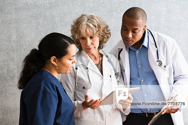 Nurse and doctors talking with digital tablet