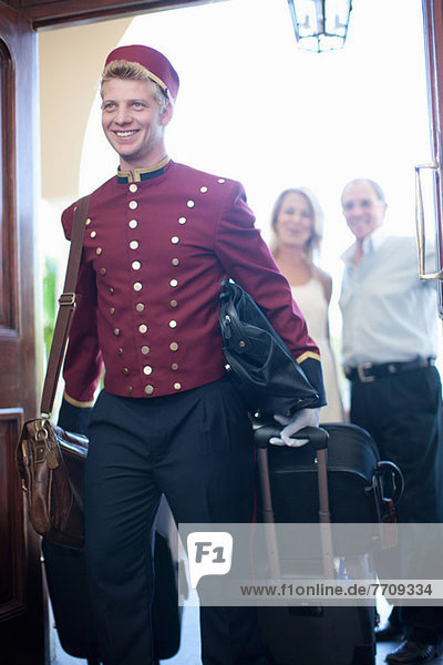 Bellhop carrying luggage in hotel