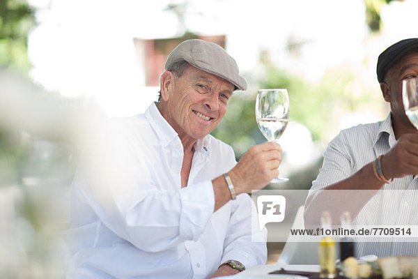 Ältere Männer beim gemeinsamen Wein trinken