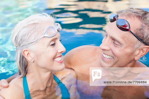 Older couple swimming in pool