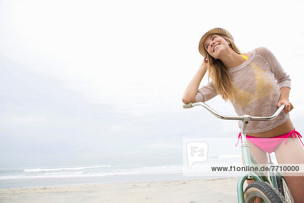 Frau auf dem Fahrrad am Strand