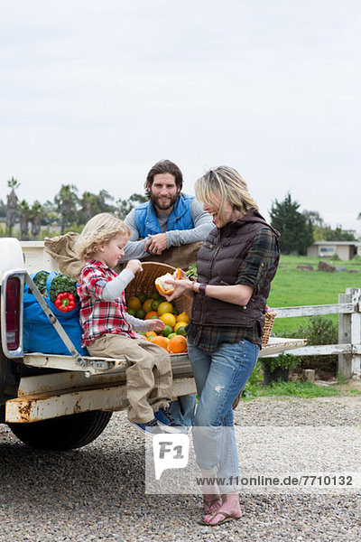 Family with produce in truck bed