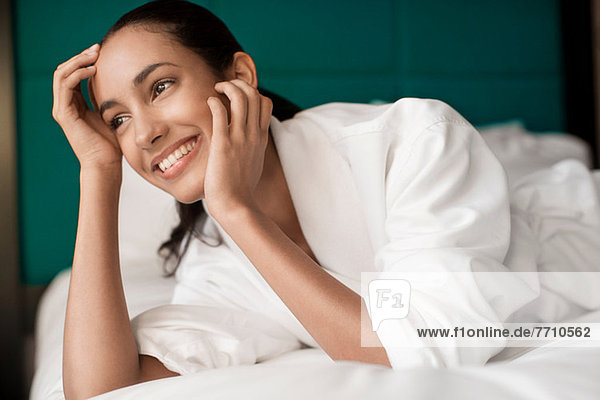 Woman in bathrobe laying on bed