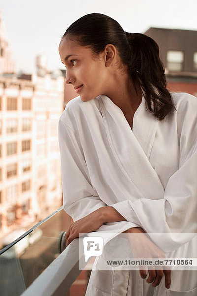 Woman wearing bathrobe on balcony
