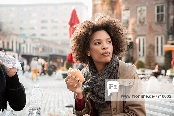 Frau isst auf der Straße in der Stadt