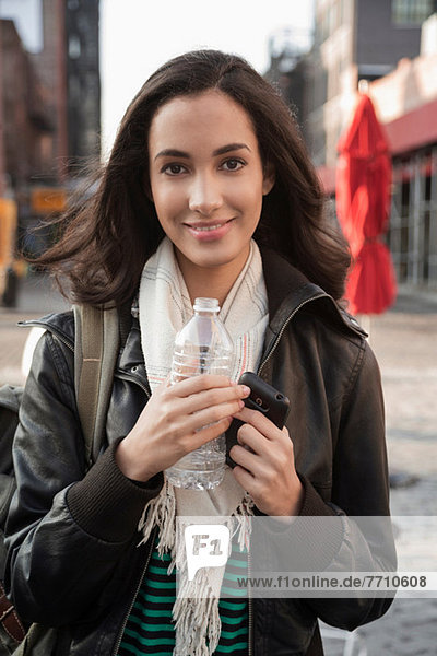 Woman drinking water on city street
