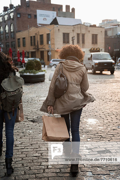Frau mit Einkaufstasche auf der Stadtstraße