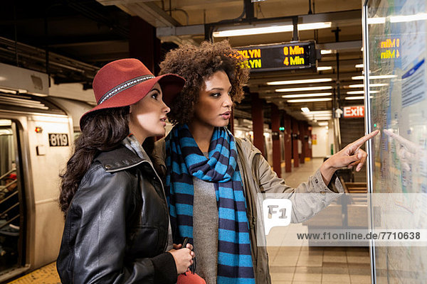 Women reading map in subway station