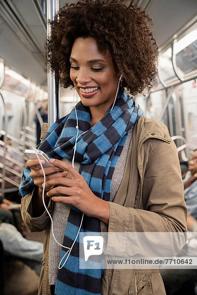 Frau hört Kopfhörer in der U-Bahn