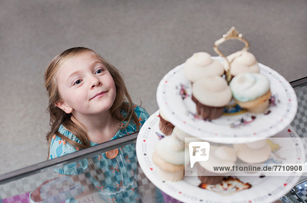 Mädchen bewundern Muffins in der Bäckerei