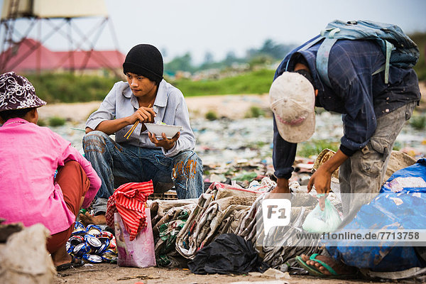Cambodia  Men pause for meal in city trash dump  Pnhom Penh