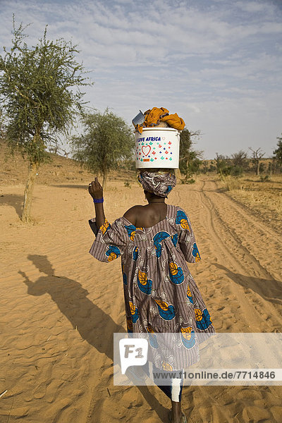 Woman Walking With Bucket On Head At Bandiagara Escarpment