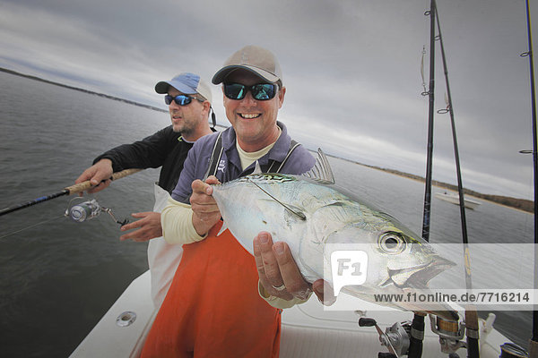 Two fisherman one holding a false albacore tuna  montauk new york usa