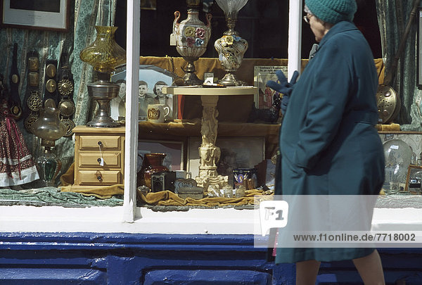 Old Woman Passing Antique Shop Window