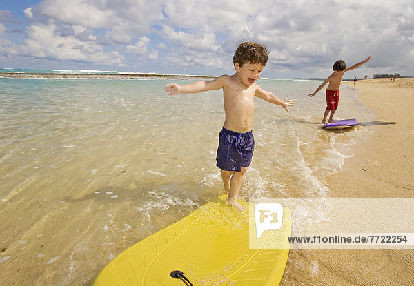 Hawaii  Maui  Spreckelsville  Baby Beach  Young Boys Playing In The Water On Boogieboards