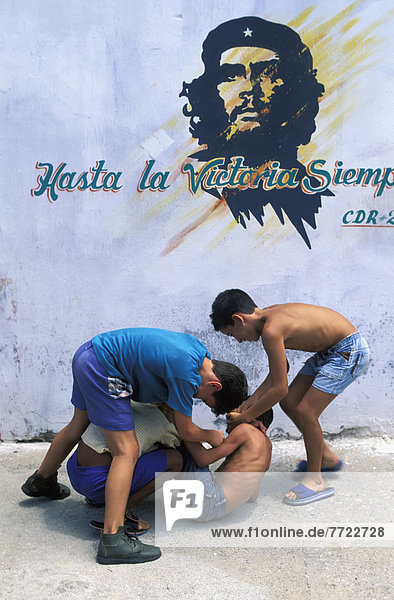 Boys Playing Beneath Wall Image Of Che Guevera