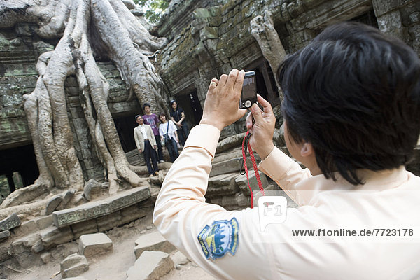 Woman Taking Photo Group Of People At Temple Of Ta Prohm  Siem Reap  Cambodia