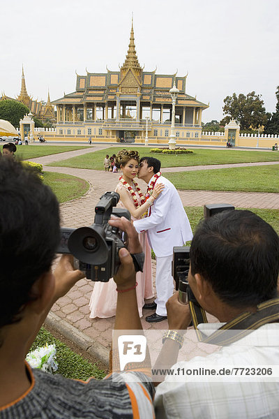 Two Men Taking Picture Newly Wed Couple In Front Of Royal Palace  Phnom Penh  Cambodia
