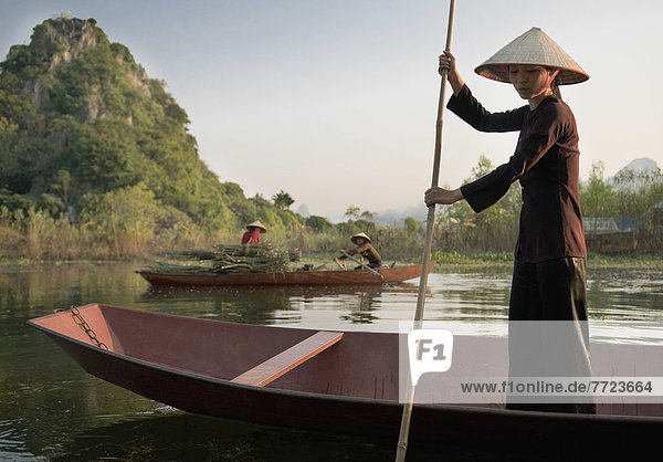 Woman Standing In Rowing Boat  Wearing Traditional Dress © Elena Roman Durante / Axiom