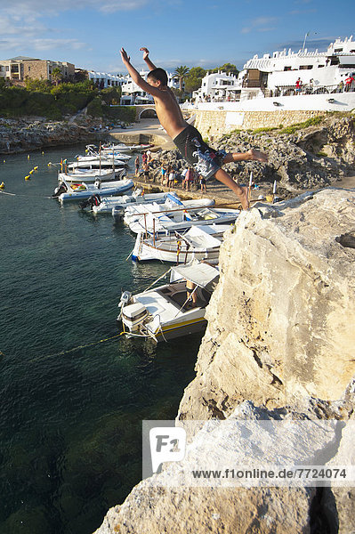 Boys Jumping Into The Sea Near The Village Of Binibequer  Menorca  Balearic Islands  Spain © Dosfotos / Axiom