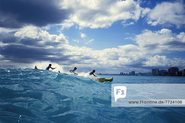 Hawaii  Oahu  Outrigger Canoe Surfing Wave  Waikiki  Buildings  Clouds