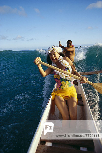 Polynesian Beauty Paddles Outrigger Canoe  Front View Of Smiling Woman Local Man In Background  Steering A38G