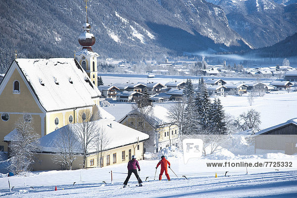 Berg bedecken Tal Kirche Dorf Ski Sehenswürdigkeit Österreich unterhalb Schnee