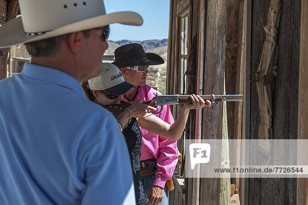 Male Instructor Guides Young Woman About How To Fire Shotgun At Lajitas Resort  Big Bend National Park And Big Bend State Park  South West Texas  Usa
