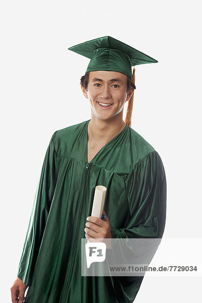Male Graduate In Cap And Gown  Holding Diploma.