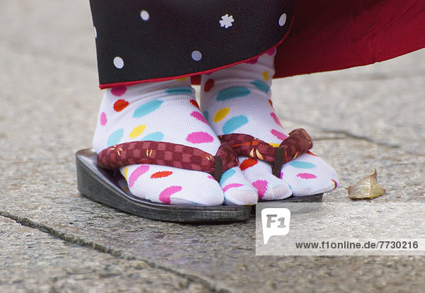 Close Up Of A Japanese Woman's Feet Wearing White Socks With Colored Dots And Sandals  Kyoto  Japan
