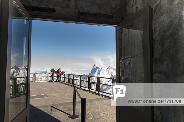People Peering Over The Edge Of A Railing At The French Alps Mountain Range  Chamonix-Mont-Blanc Rhone-Alpes France