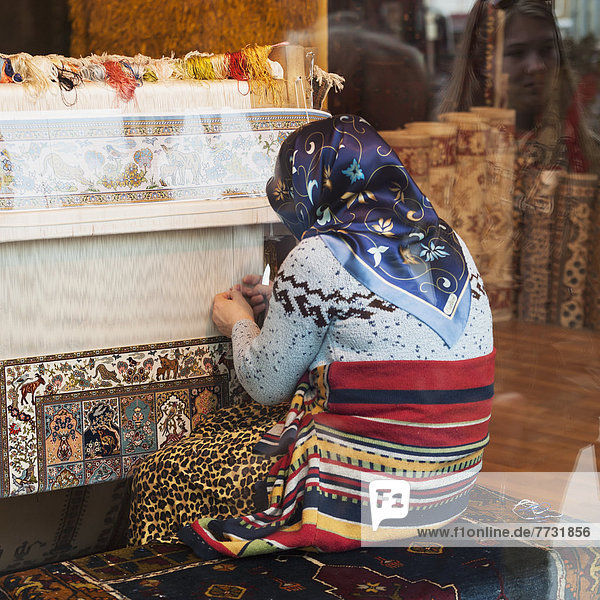 A Woman Kneeling As She Weaves On A Loom  Istanbul Turkey